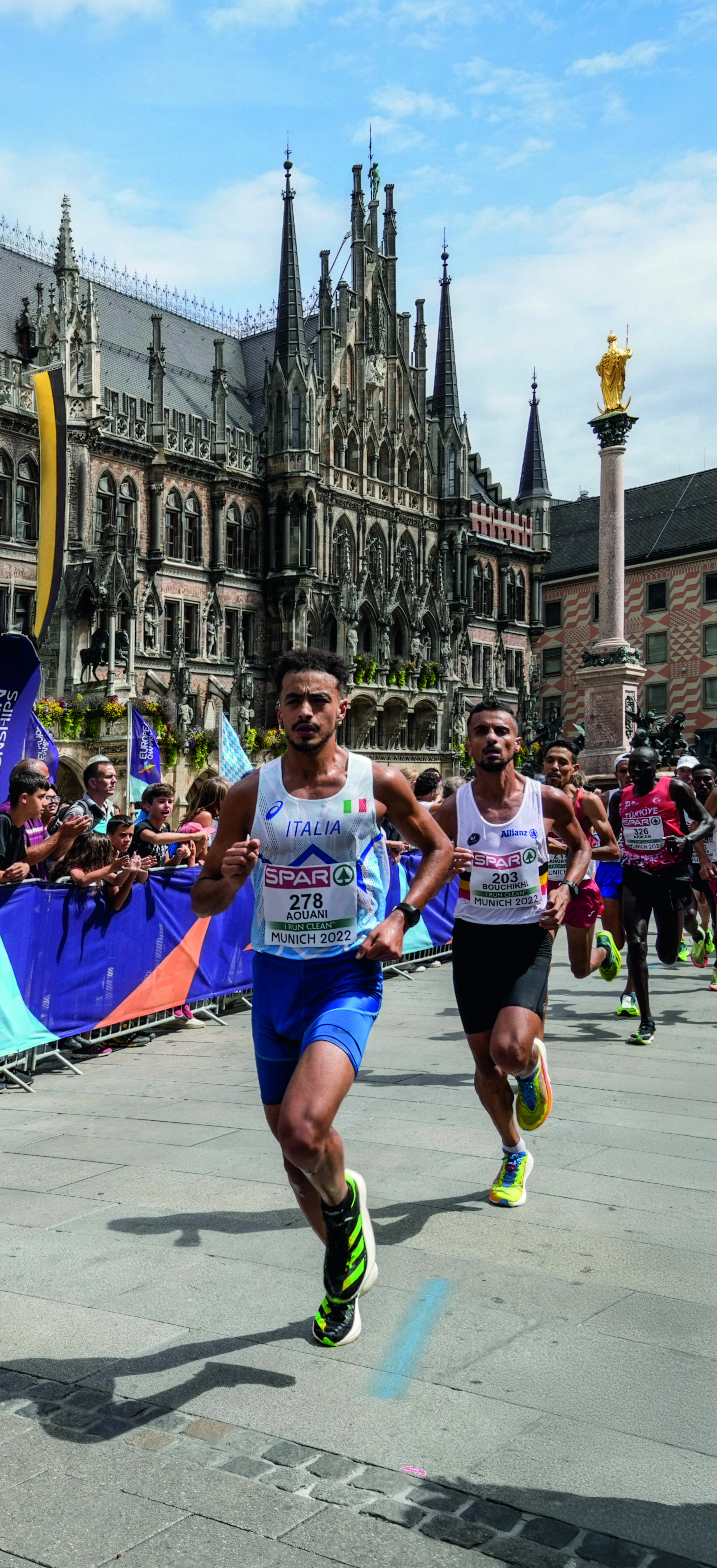 Marathonläufer auf dem Marienplatz in München mit anfeuerndem Publikum